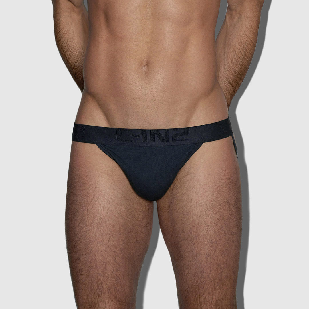 A close-up of a male model's lower torso wearing dark navy blue athletic jock with a wide elastic waistband featuring the brand name 'C-IN2' in tonal lettering.