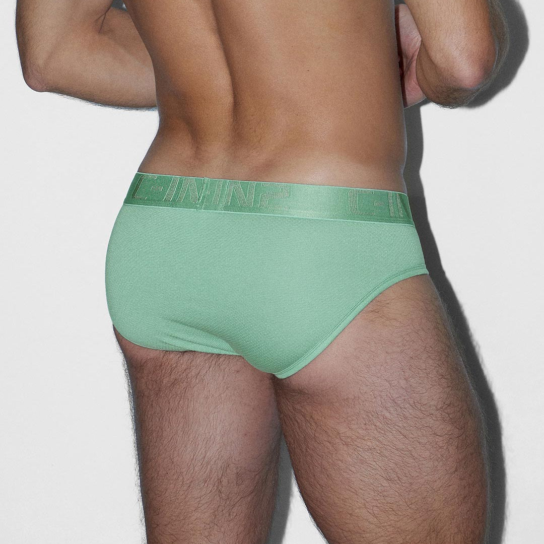 Man wearing green men's underwear on a plain background