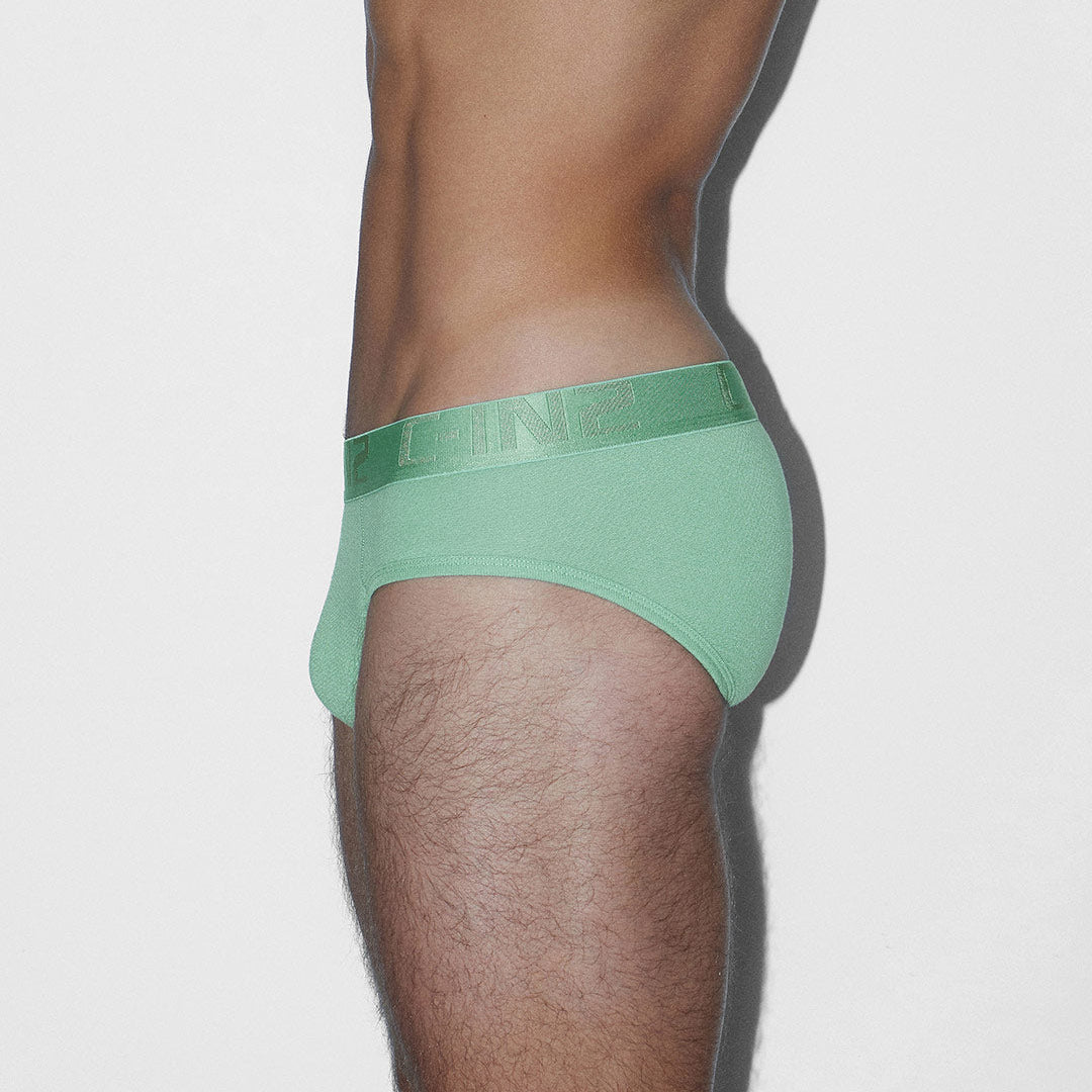 Green underwear worn by a person on a light gray background