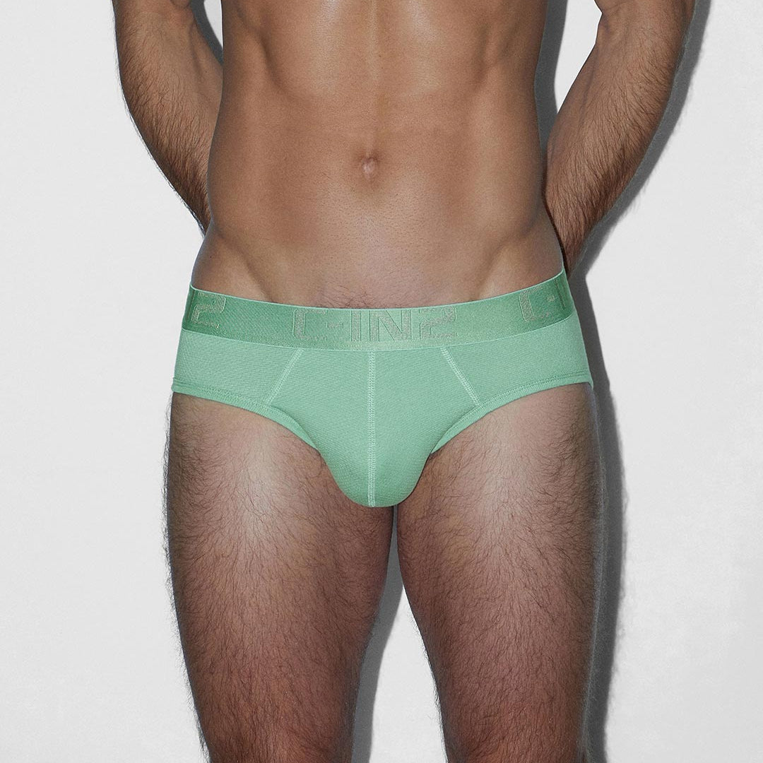 Man wearing a green underwear on a plain background