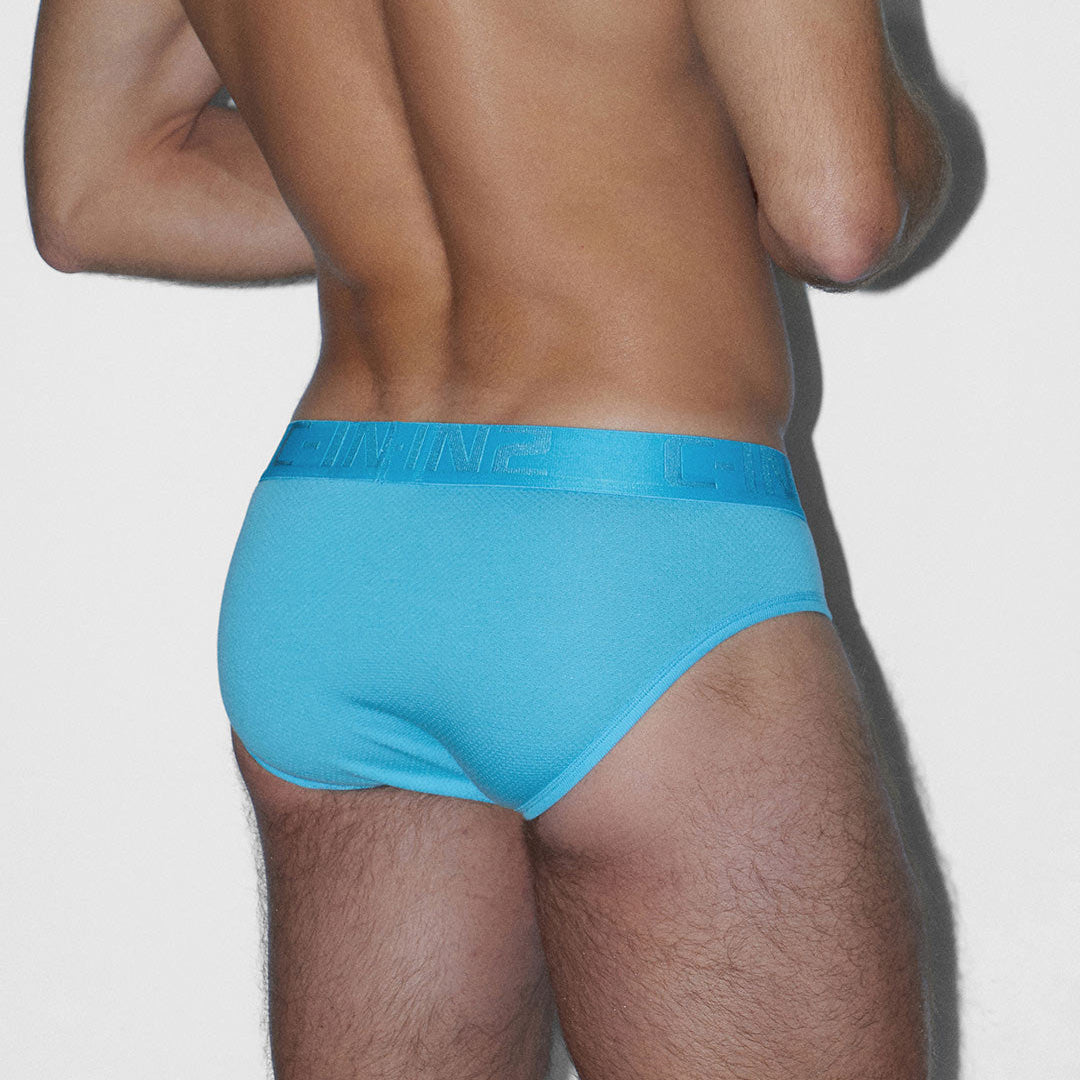Person wearing a blue underwear on a plain background