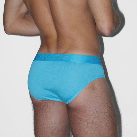 Person wearing a blue underwear on a plain background