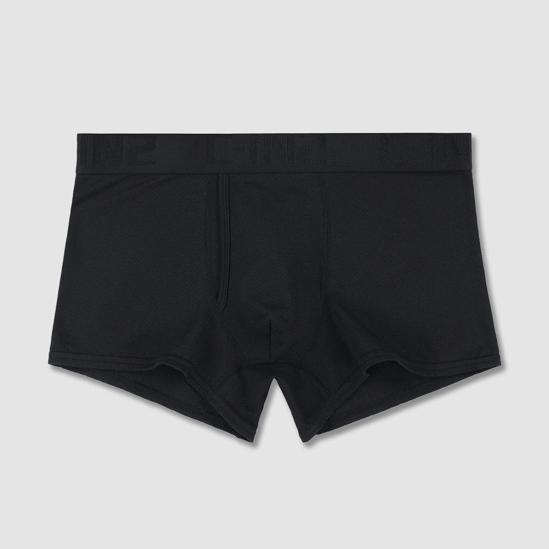 Black men's boxer briefs on a flat surface on a light gray background.