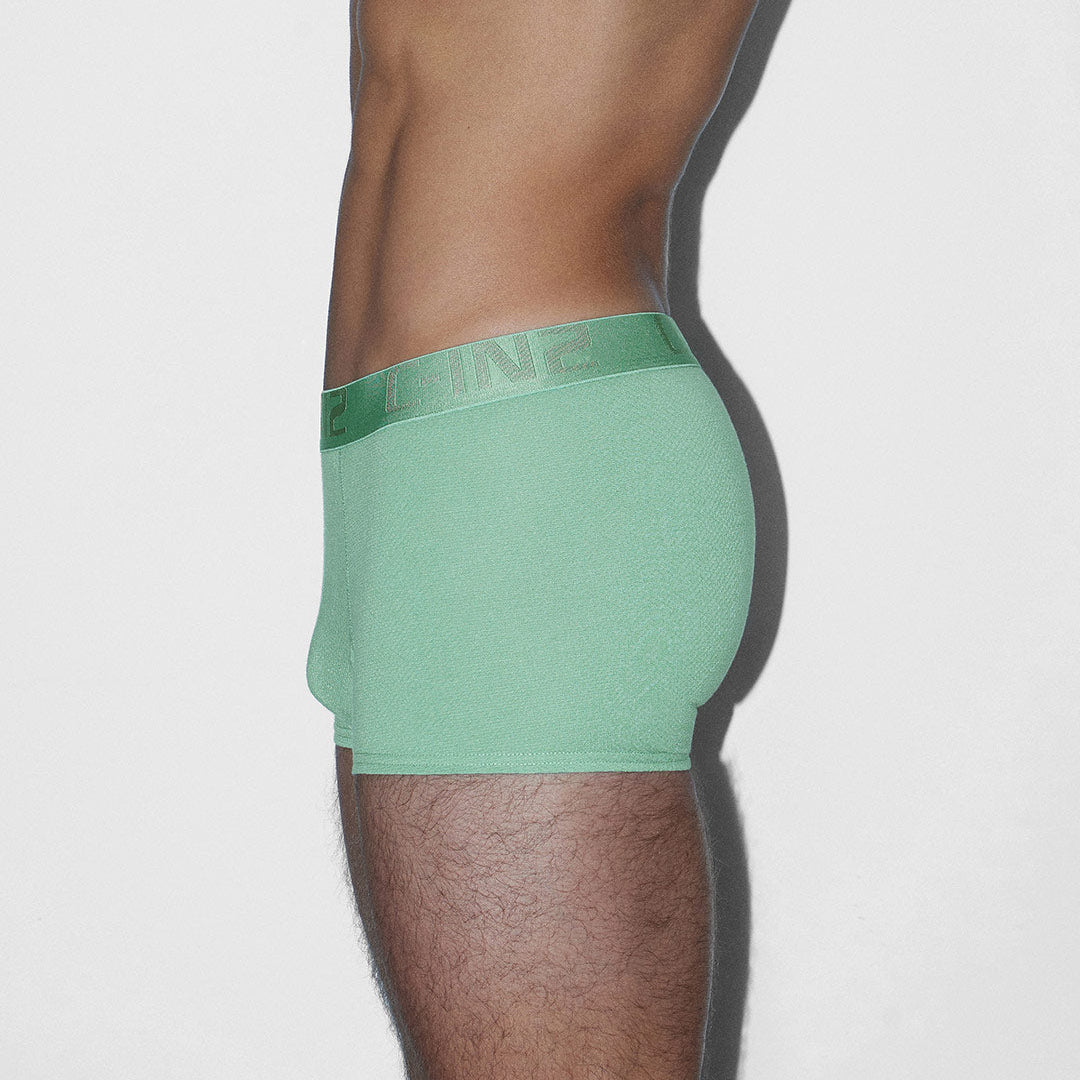 Green underwear worn by a person on a white background