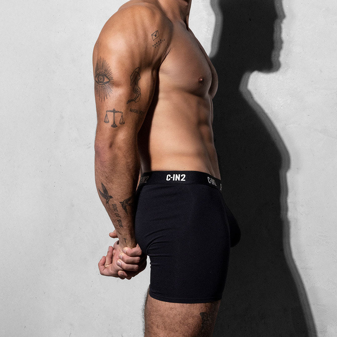 Man wearing black underwear with a visible C-IN2 brand logo against a plain background