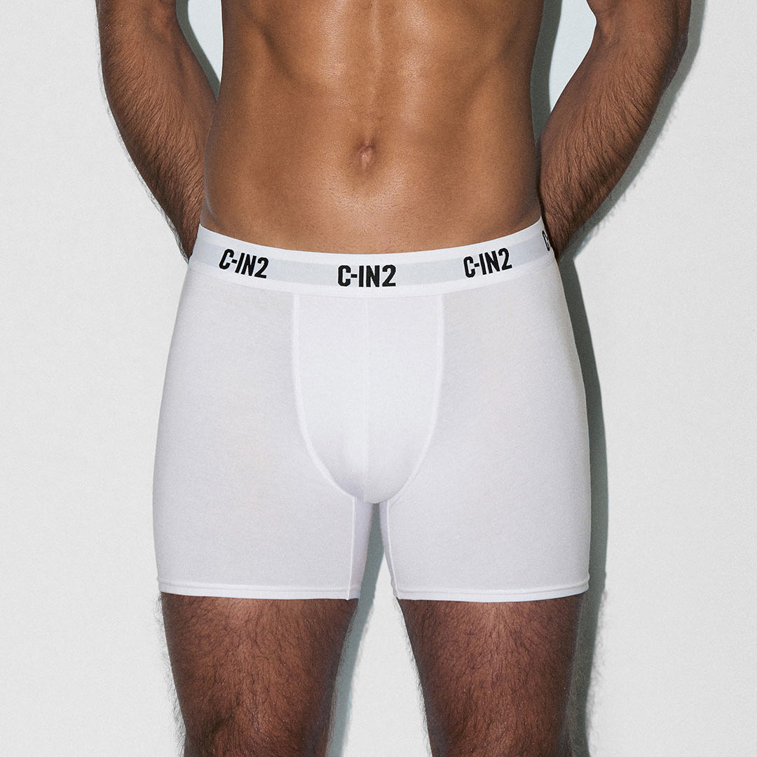 Person wearing white boxer briefs with 'C-IN2' branding on a light gray background