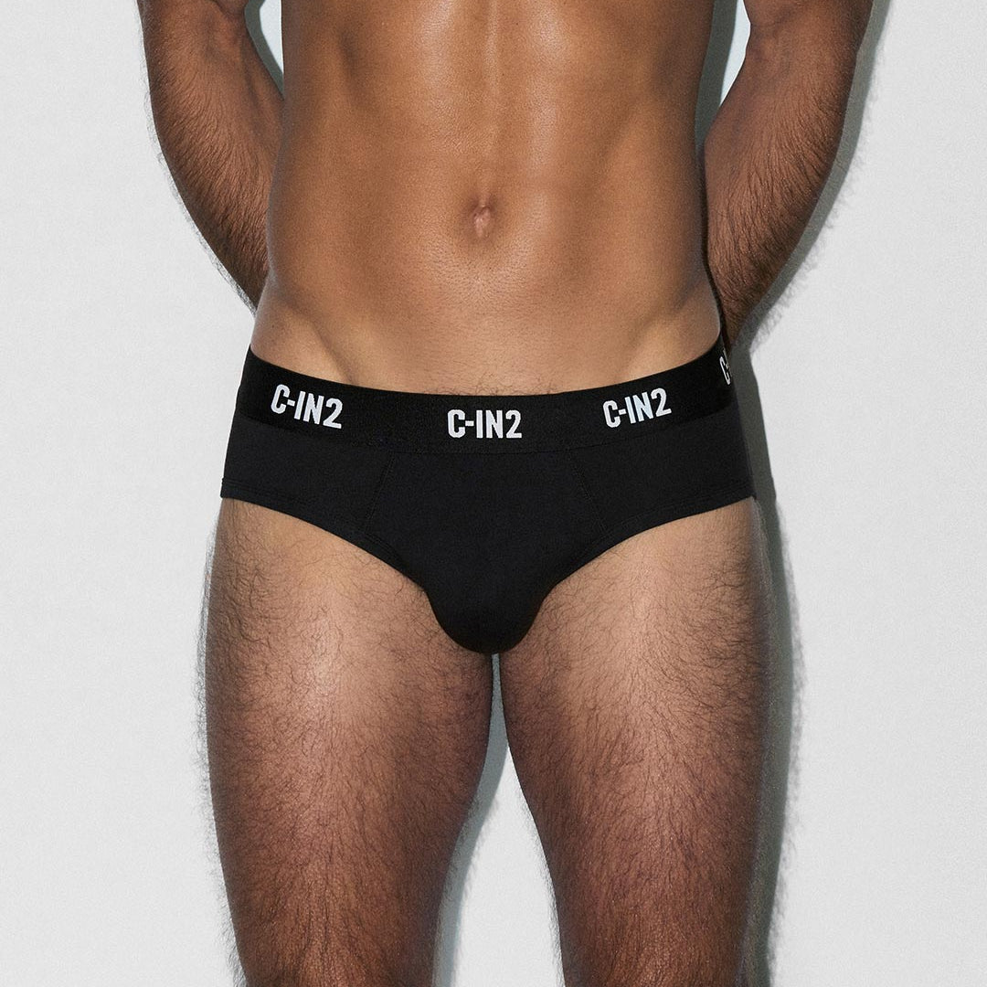 Man wearing black men's underwear with 'C-IN2' branding on a light gray background