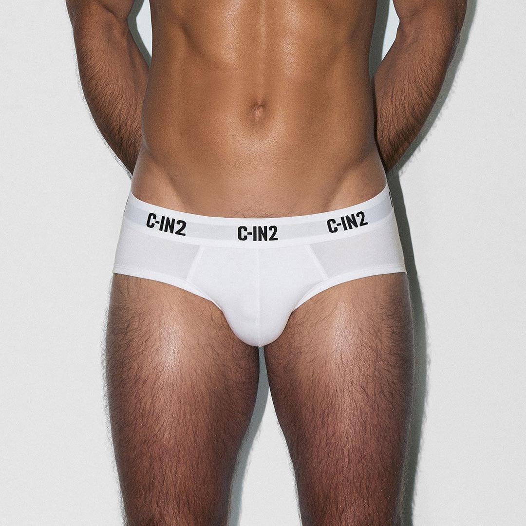 Man wearing white underwear with 'C-IN2' branding on a light gray background