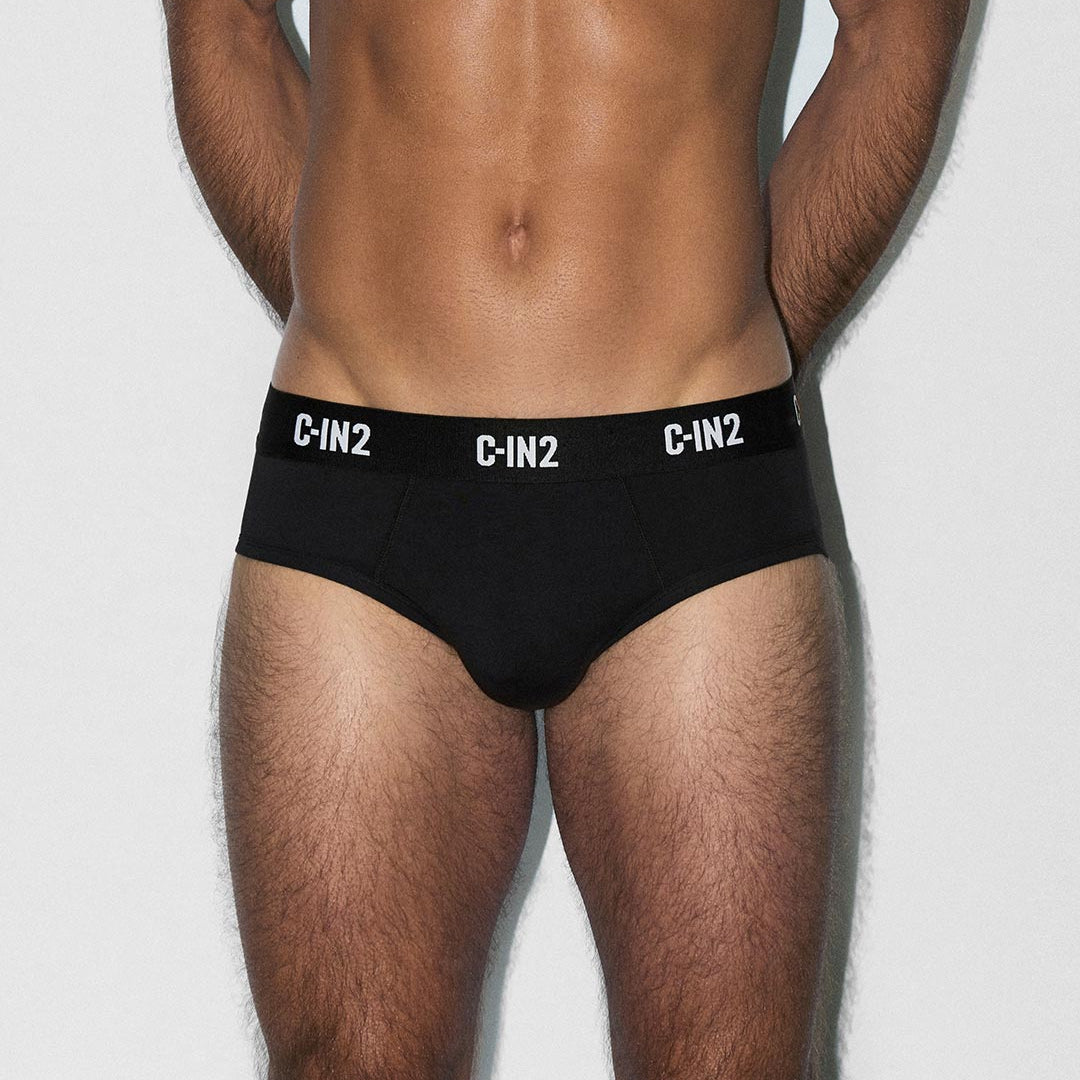 Man wearing black underwear with 'C-IN2' branding on a white background