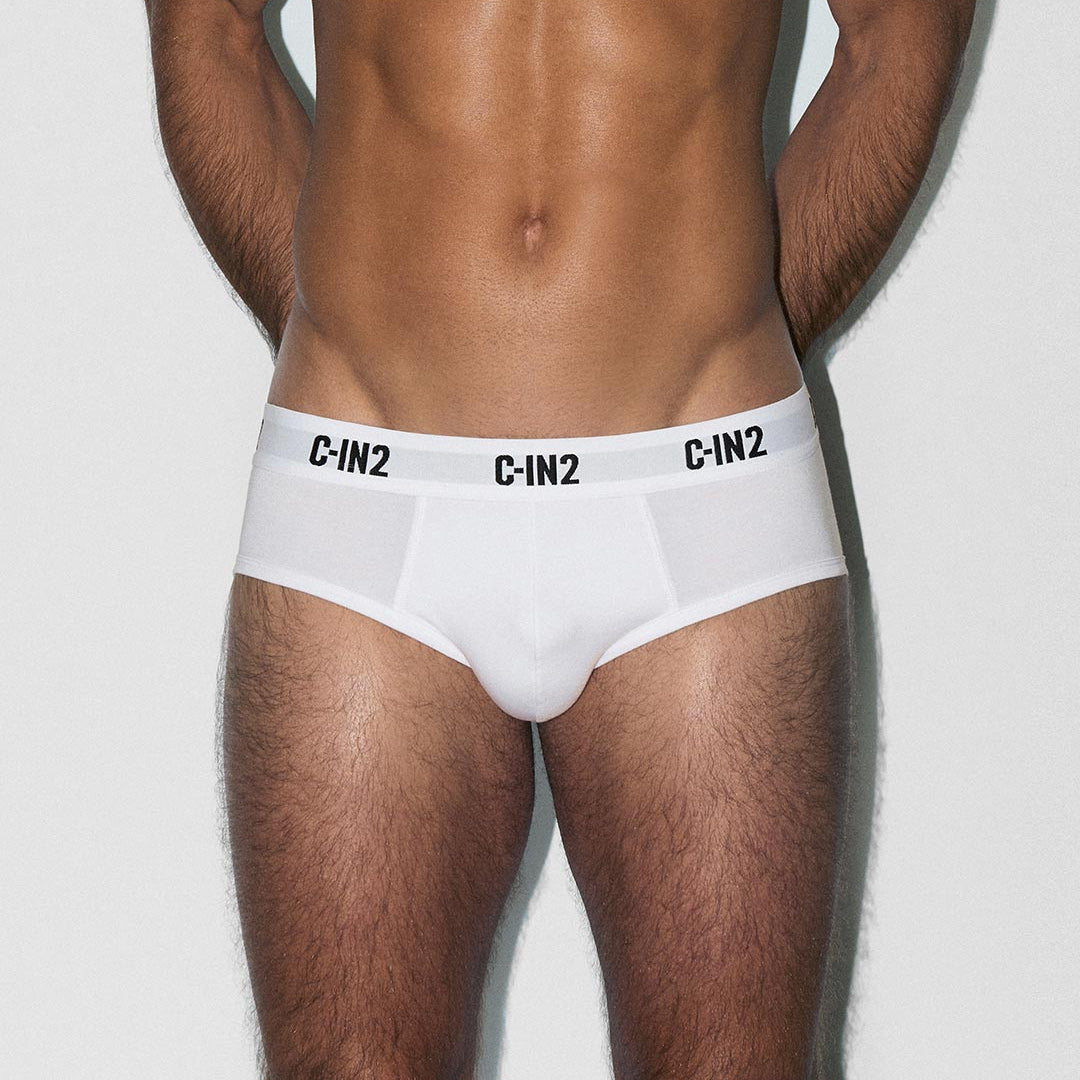 Man wearing white underwear with 'C-IN2' brand logo on a light gray background