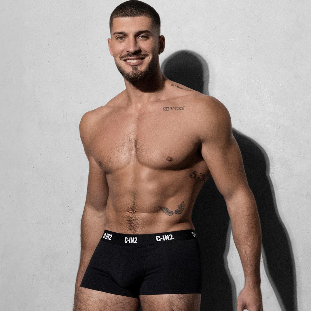 Man wearing black underwear with a visible C-IN2 brand logo against a plain background