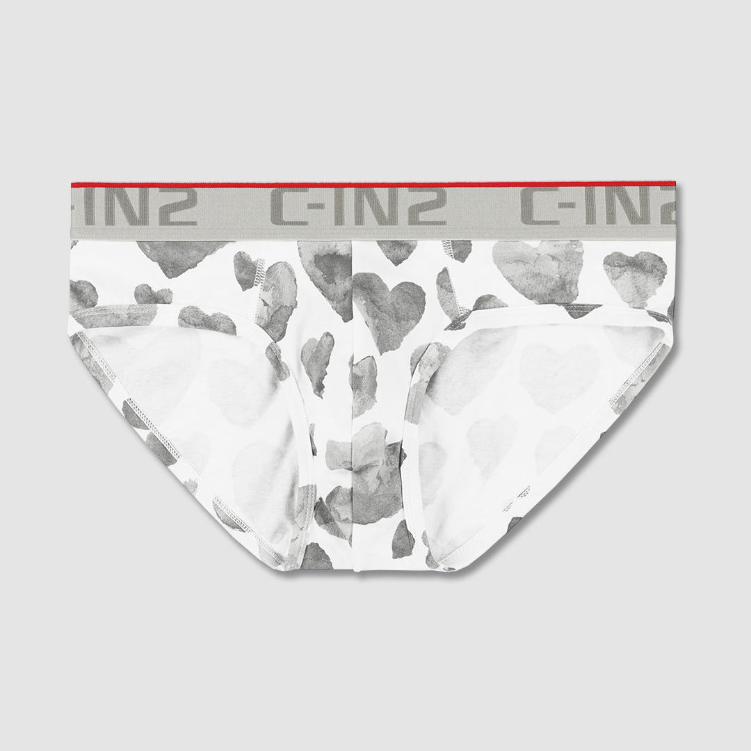 White briefs with a gray watercolor heart pattern and a gray elastic waistband featuring the C-IN2 brand name.