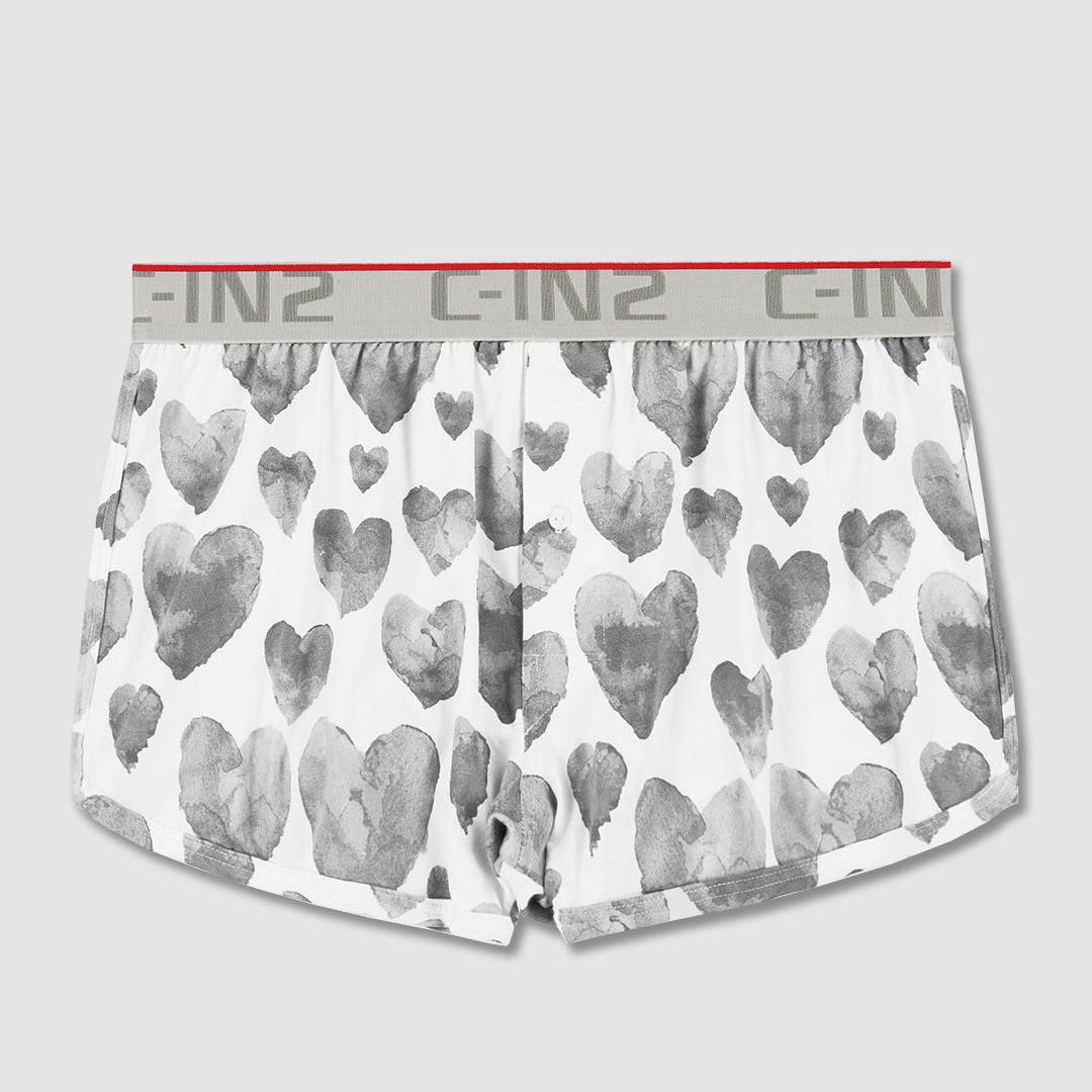 White boxer briefs with a gray watercolor heart pattern and a gray elastic waistband featuring the C-IN brand logo.