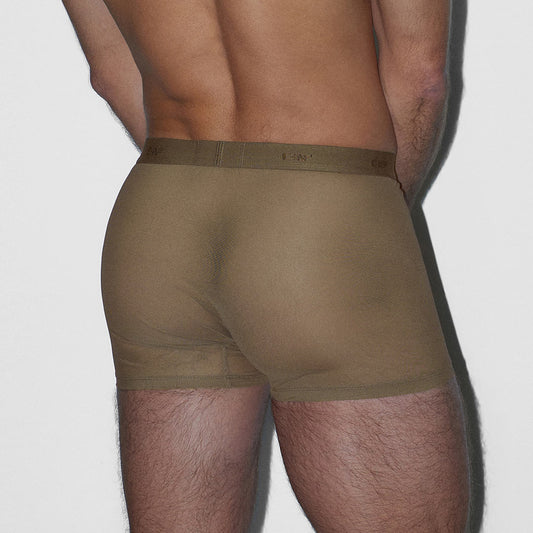 Man wearing olive green boxer briefs on a white background