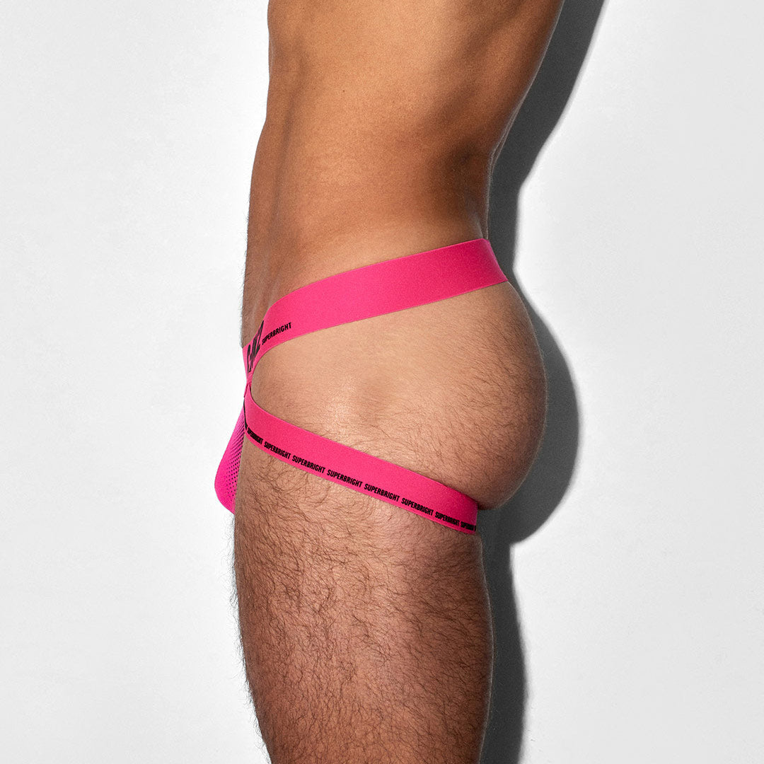 Person wearing a bright pink jock against a white background