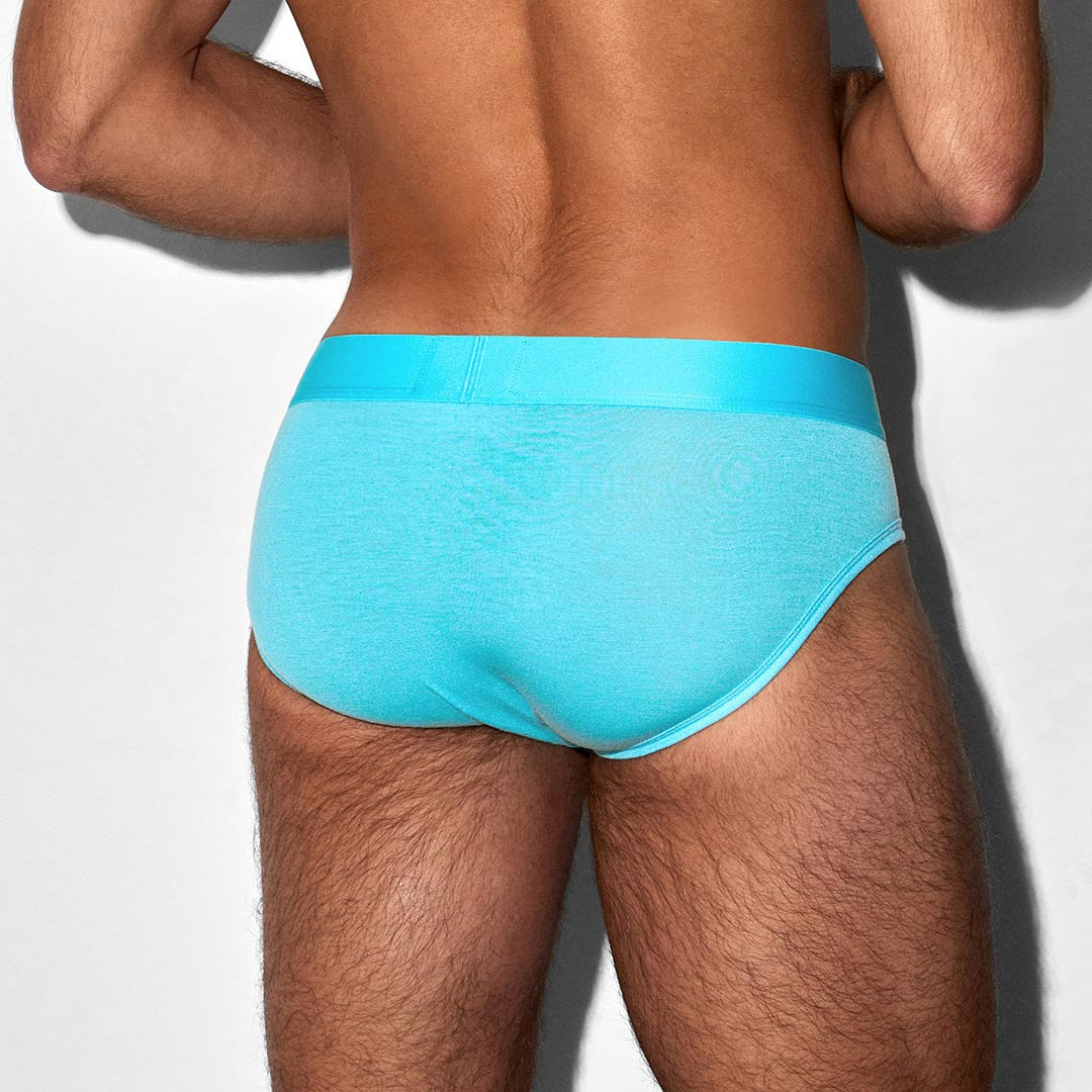 Person wearing a turquoise underwear on a light gray background