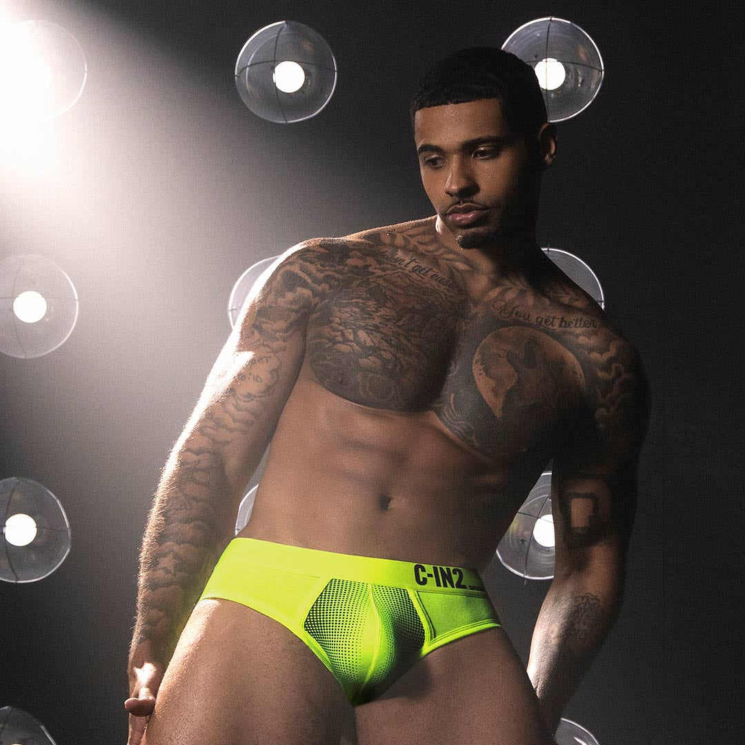 Man wearing a bright green underwear with a dark background