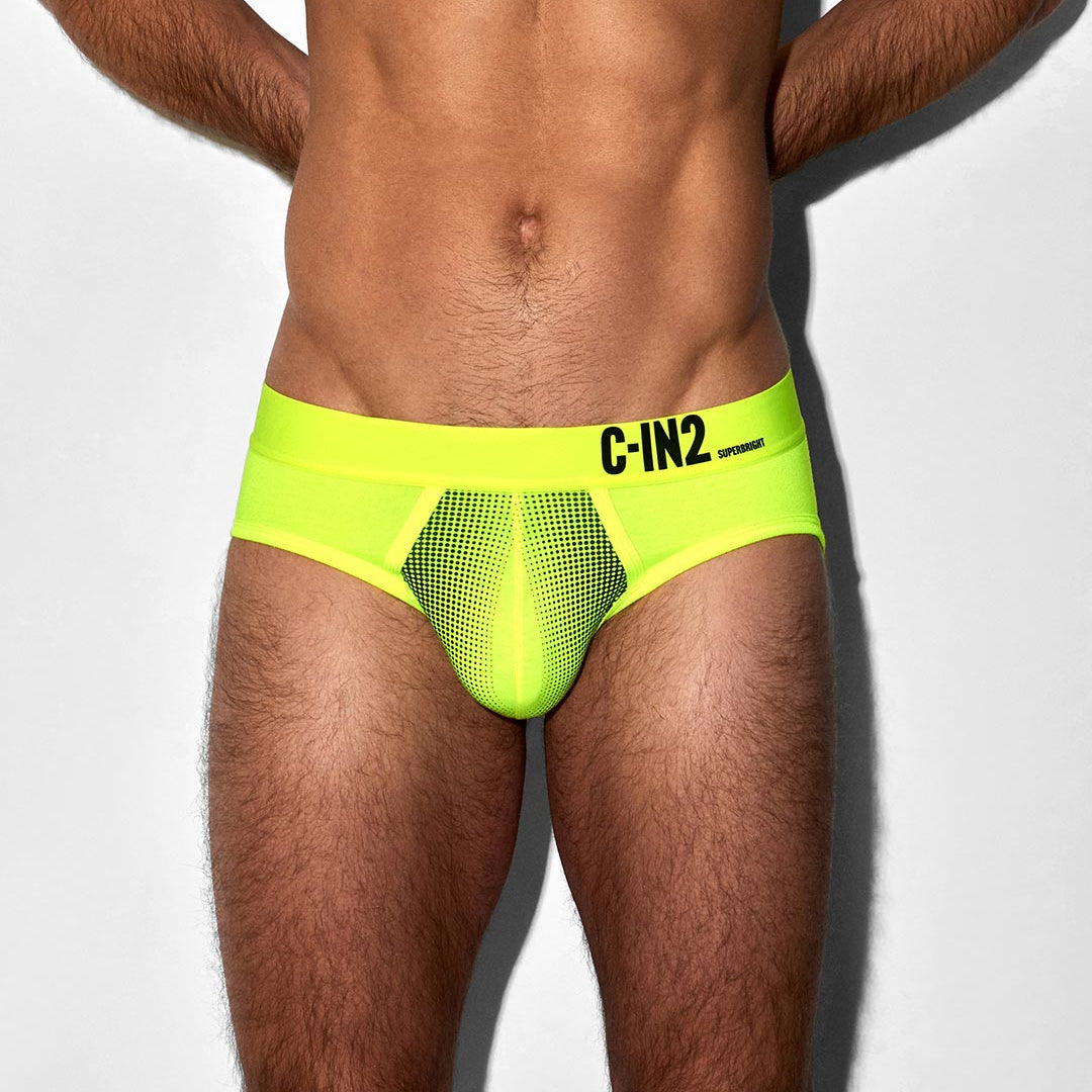 Person wearing a bright green men's underwear with 'C-IN2' branding on a white background