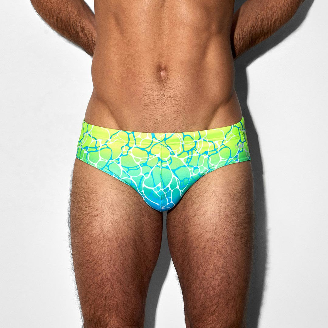 Man wearing a colorful swim brief with C-IN2 logo on a white background