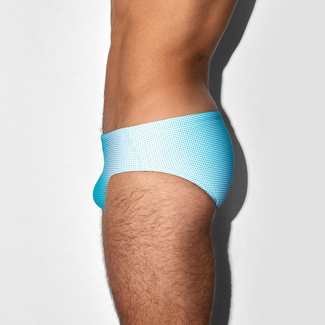 Light blue men's bikini swim brief worn by a person on a white background