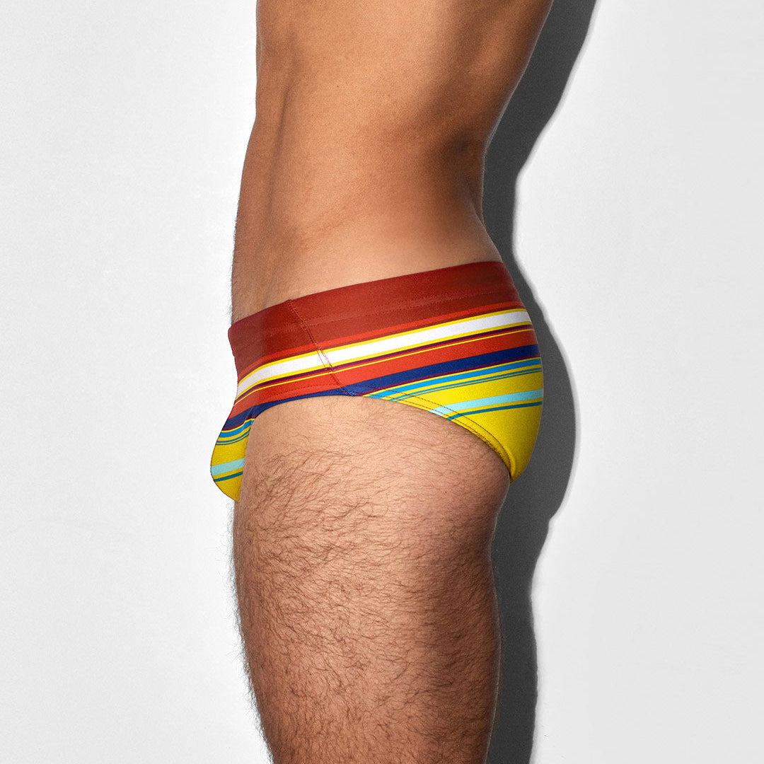Colorful swim briefs worn by a person on a white background