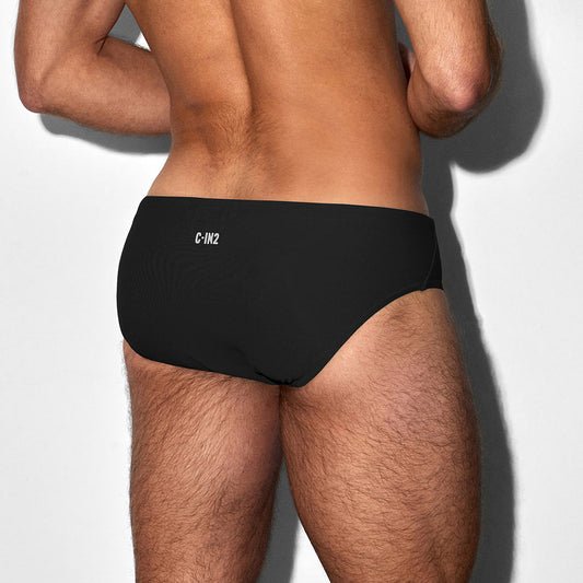 Man wearing a black swim brief with 'C-IN2' branding on a white background