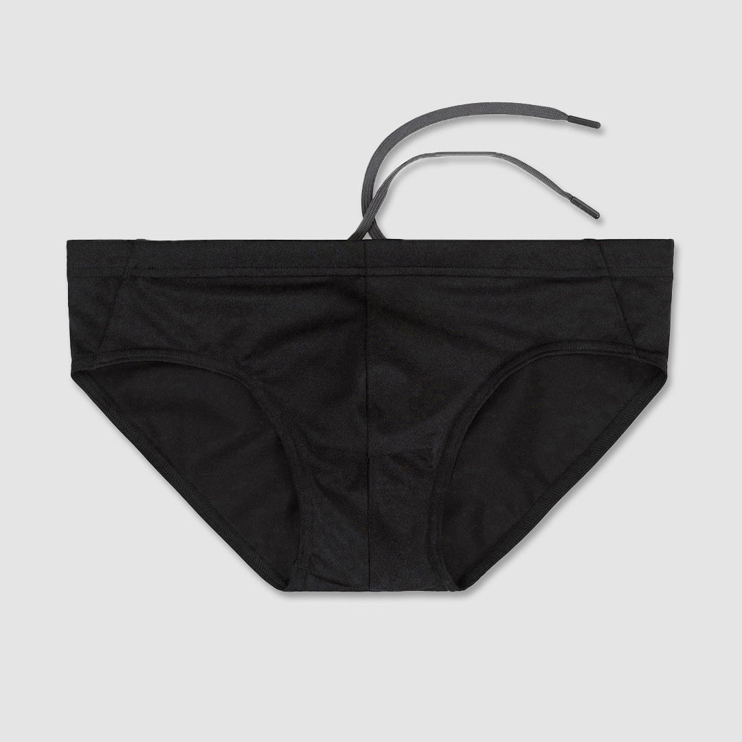Black men's bikini bottoms with a thin black waist tie, laid flat on a light gray background.