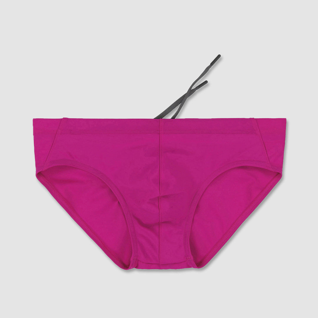 Raspberry pink men's bikini bottom on a light gray background