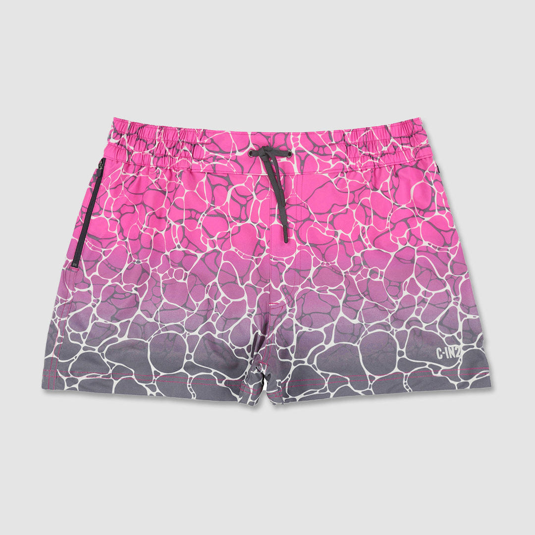 A pair of athletic shorts featuring a pink-to-gray gradient with a white cracked stone pattern, a black drawstring waist, and black side zippers, and C-IN2 branding shown against a light gray background.