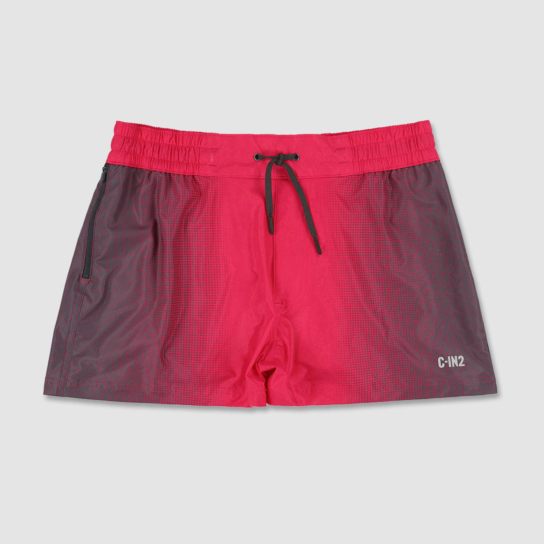 A pair of swim shorts with a vibrant pink to dark gray gradient design, featuring an elastic waistband with a black drawstring and a small white 'C-IN2' logo on the lower right leg.