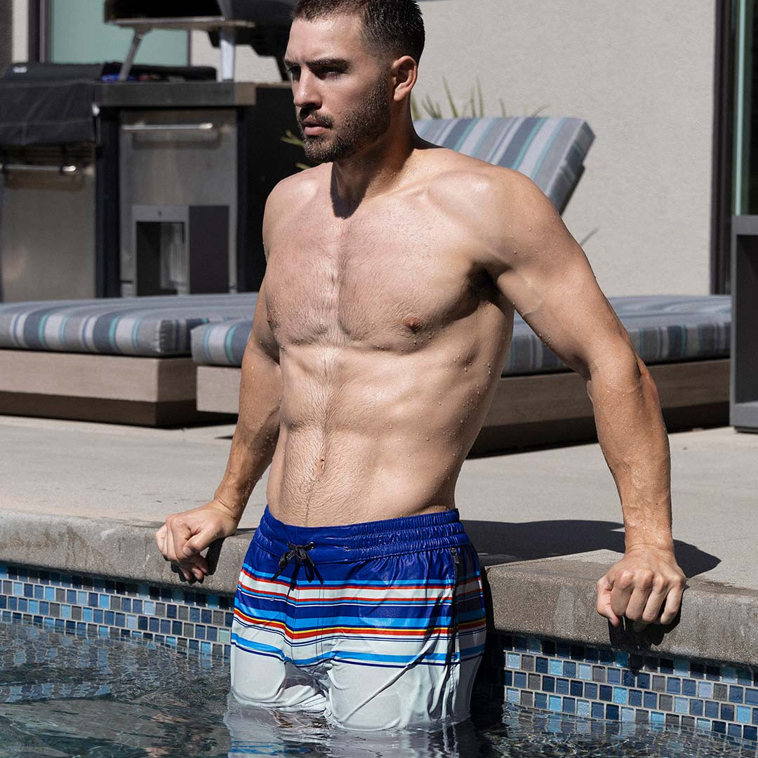 Man in striped swim trunks standing in a pool
