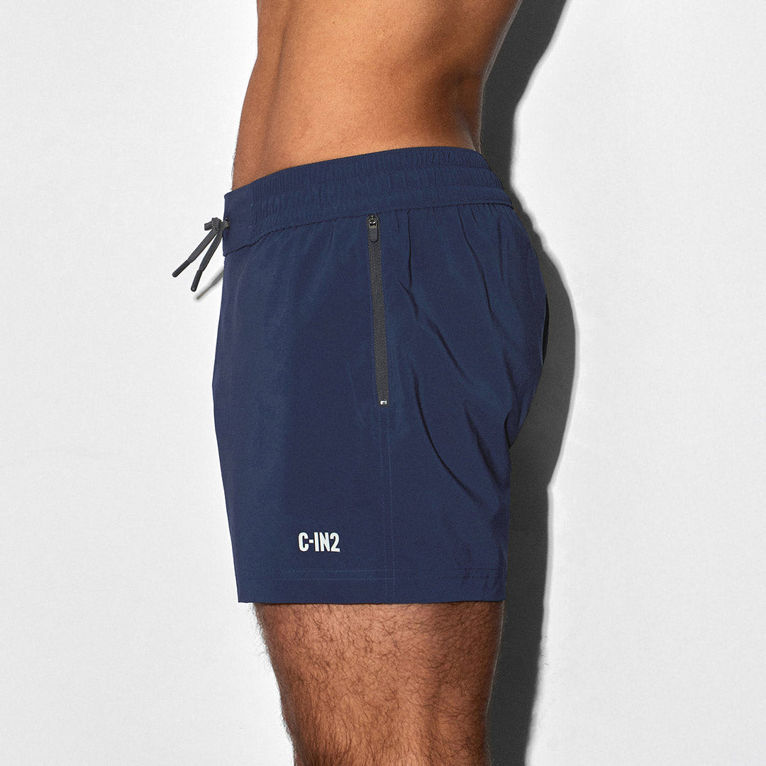 Side image of person wearing navy blue swim shorts with a C-IN2 brand logo on a white background
