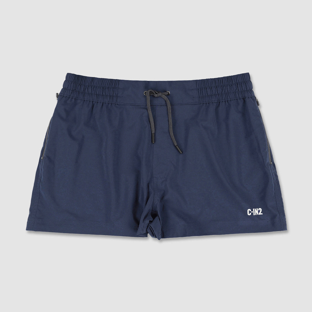 A pair of navy blue athletic swim shorts with an elastic waistband and a black drawstring, featuring a white 'C-IN2' logo on the lower left hem, displayed against a light gray background.