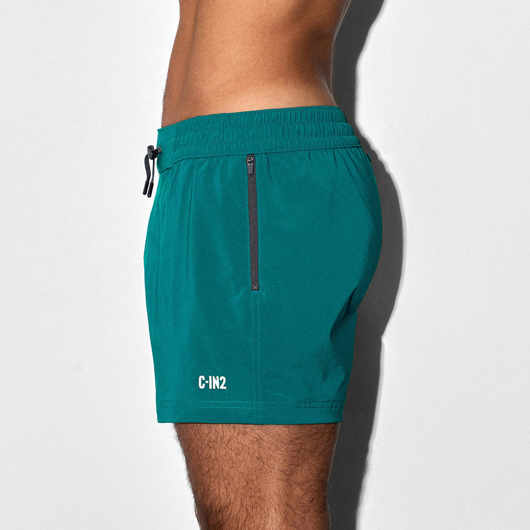 Teal swim shorts with a 'C-IN2' brand logo on a white background