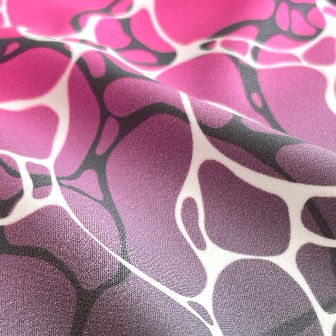 Close-up of fabric with pink, purple, and black abstract pattern