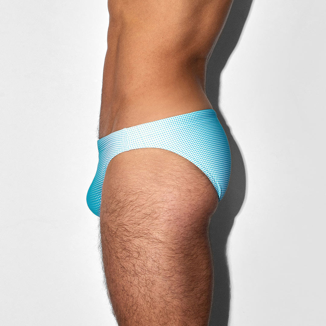 Light blue men's bikini swim brief worn by a person on a white background