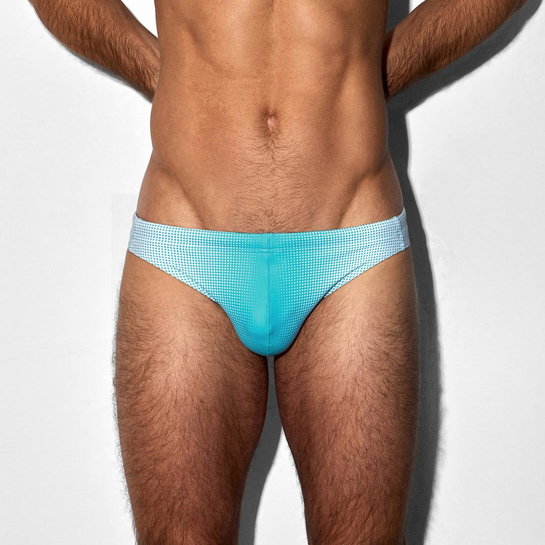 Man wearing light blue swim briefs on a white background