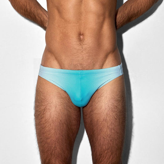 Man wearing light blue swim briefs on a white background