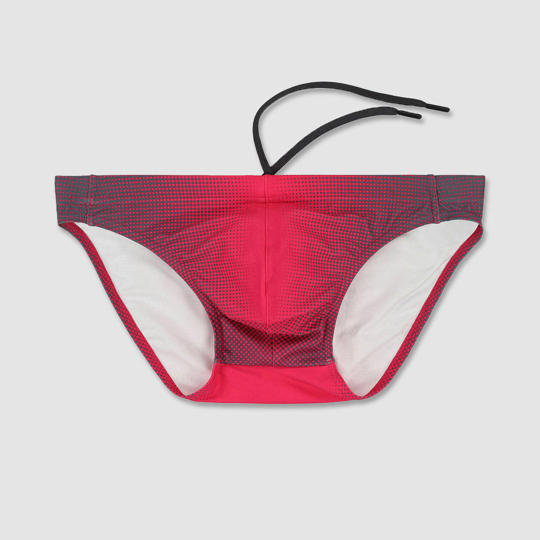 A pair of men's bikini bottoms in a vibrant red and dark gray micro-check pattern, featuring a solid red inner lining and a black adjustable waistband strap, shown flat on a light gray background.