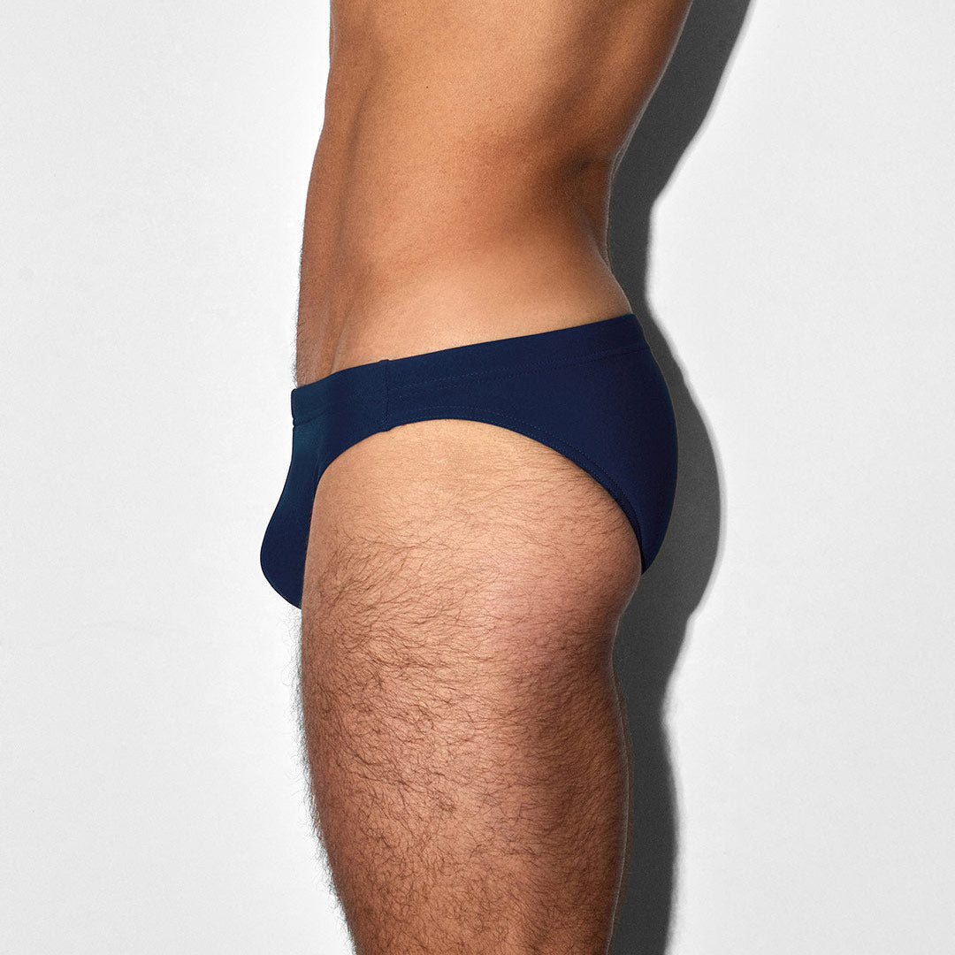 Navy blue men's swim brief on a white background