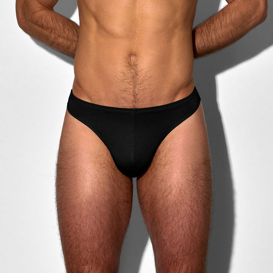 Man wearing a black men's swim thong on a white background