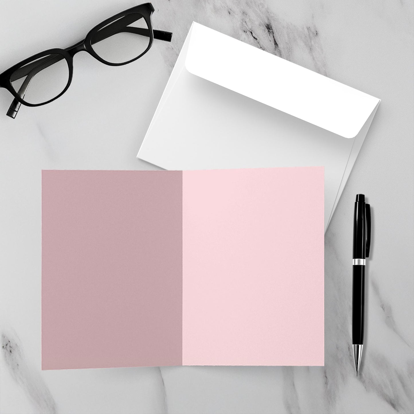 Blank inside card in pink, pen, and glasses on a marble surface