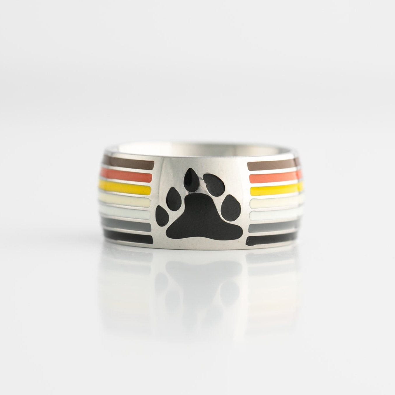 Ring with paw print design and gay bear pride stripes on a white background