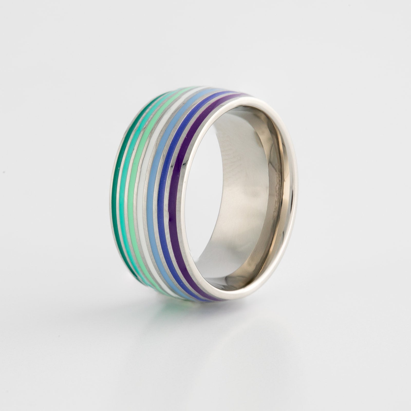 Silver ring with gay mlm pride flag colored stripes on a light gray background