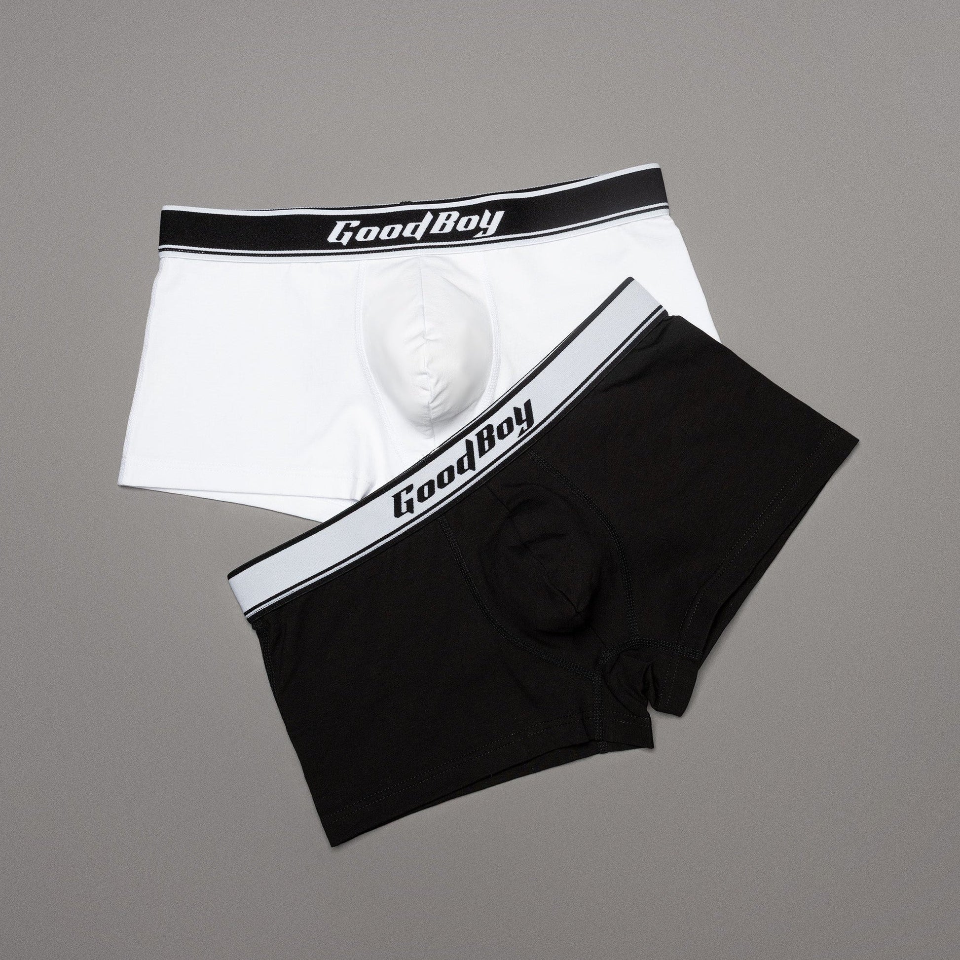 Black and white boxer briefs with 'Good Boy' waistband on a gray background
