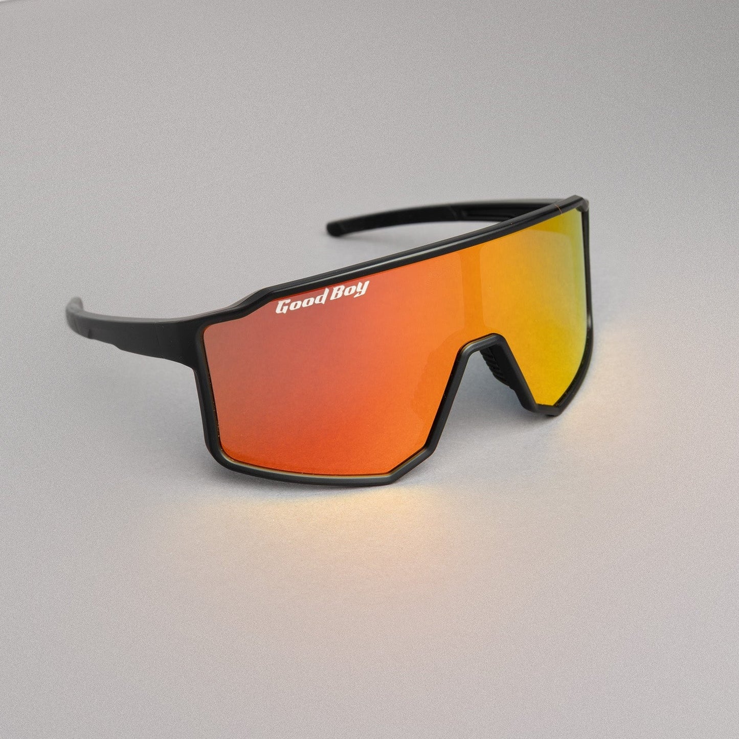 Sunglasses with orange lenses and black frame on a gray surface