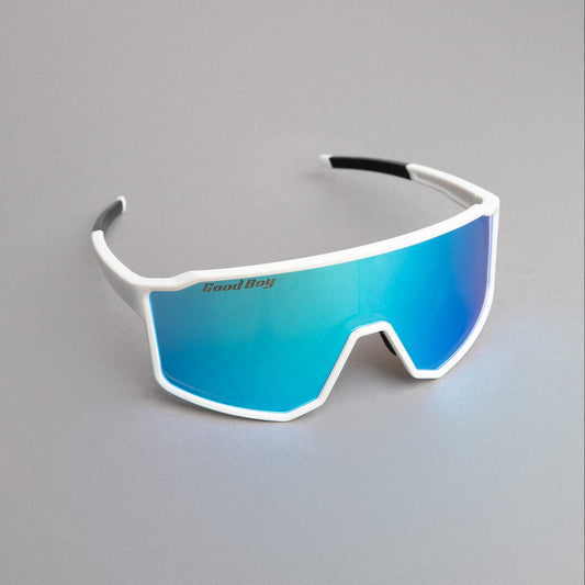 Sunglasses with blue reflective lenses and white frame and 'Good Boy' brand on a gray surface