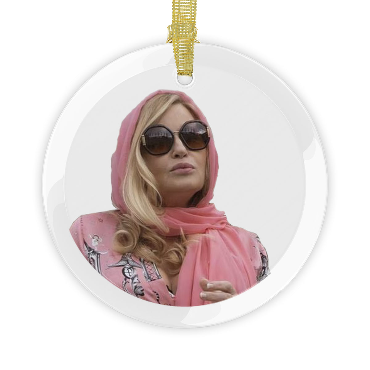 Round crystal clear holiday ornament with image of actress Jennifer Coolidge wearing sunglasses and pink head wrap and blouse.