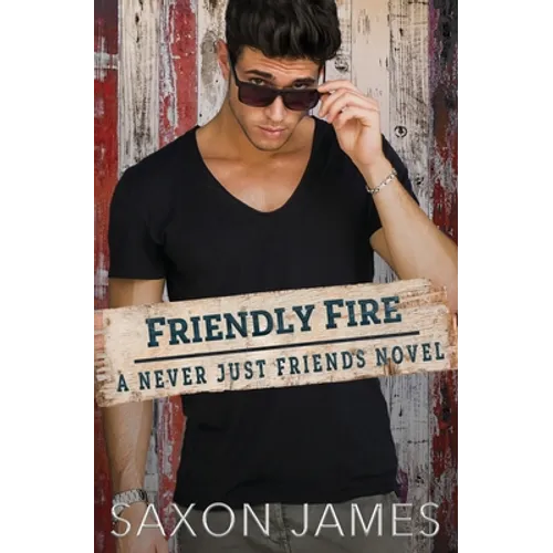 Man holding a book titled 'Friendly Fire' by Saxon James against a wooden background