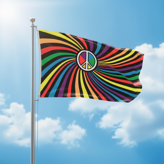 A colorful flag with a rainbow spiral pattern and a peace symbol in the center, flying on a silver flagpole against a blue sky with clouds.